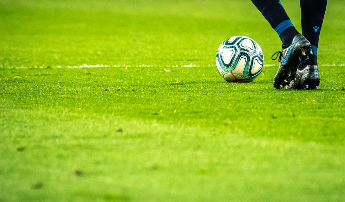 Pemain sepak bola berlomba merebut bola di lapangan hijau