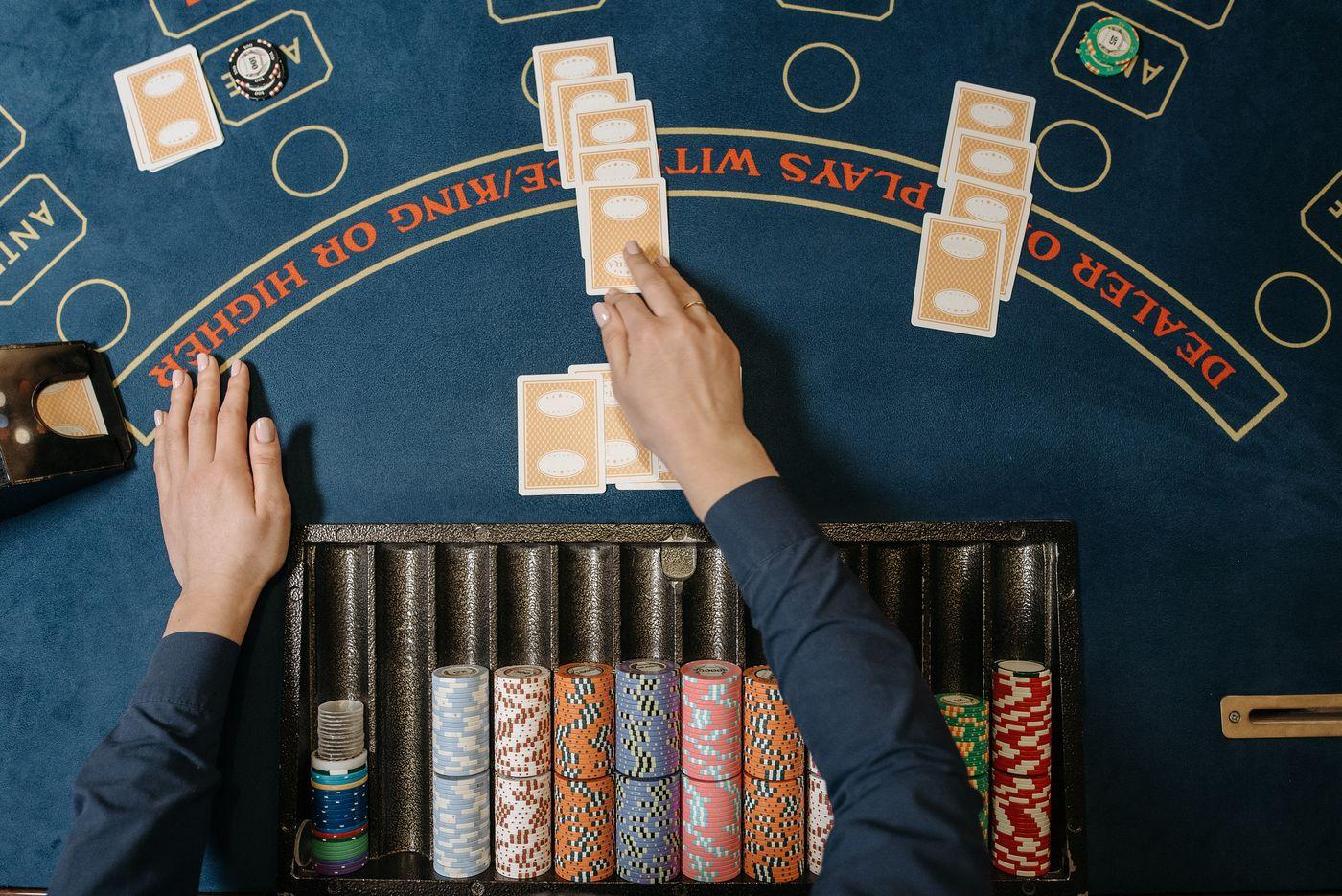 Dealer membagikan kartu di meja blackjack kasino langsung