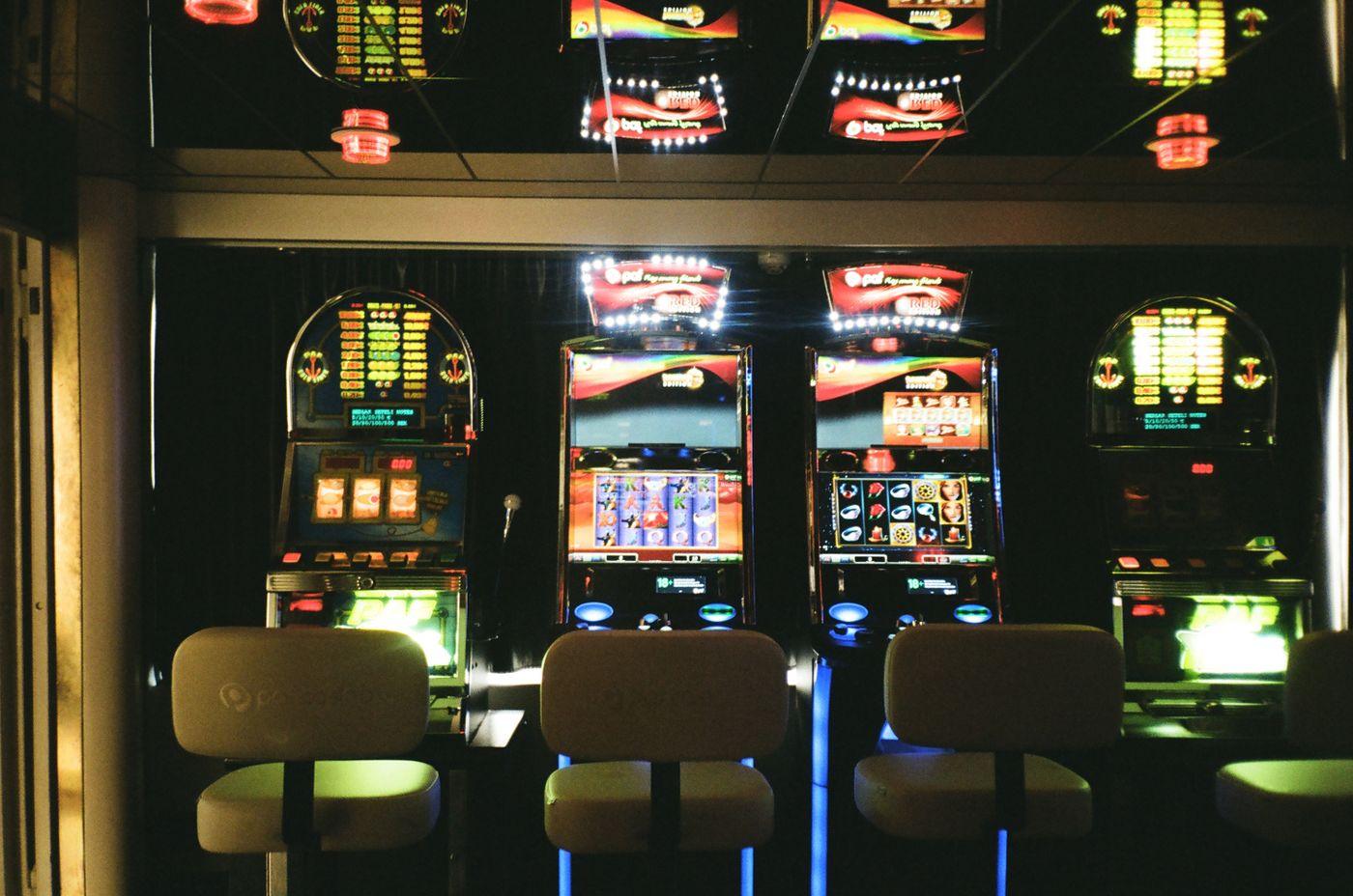Barisan mesin slot menyala di lantai kasino yang temaram