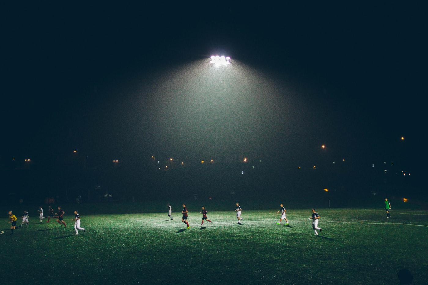 Pertandingan sepak bola di bawah lampu stadion malam